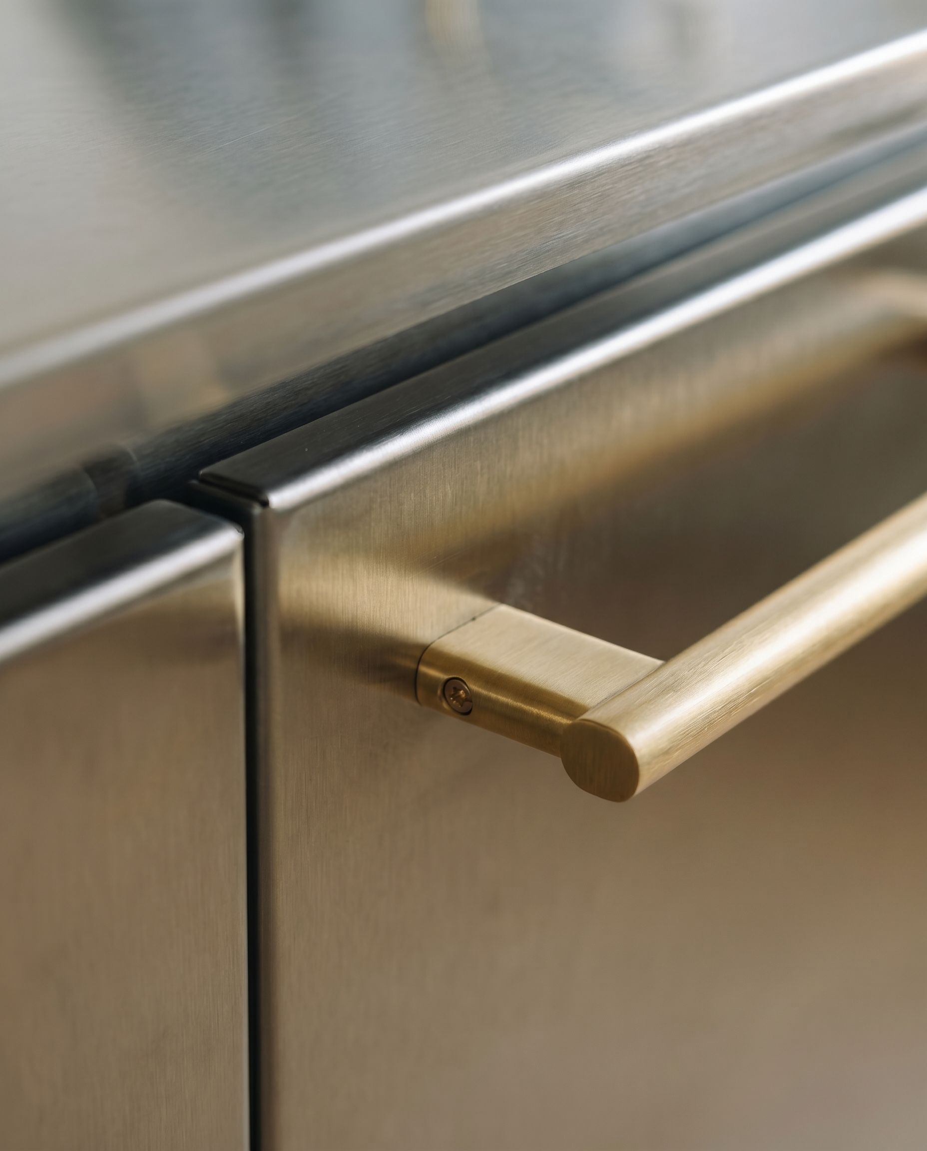 Arbeitsplatte aus Edelstahl mit Messing-Armatur in Donzdorfer Küche.